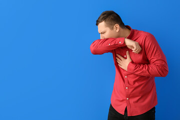 Coughing young man on color background