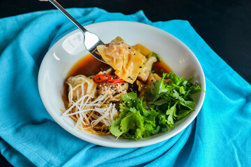 Boiled meat dumplings with fresh parsley, soy sauce and sesame seeds. Delicious meal for dinner.