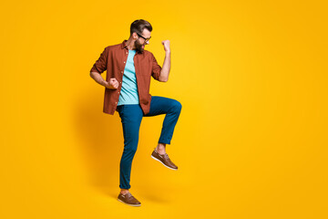 Fototapeta na wymiar Full length body size photo of happy man in casual outfit gesturing like winner isolated on vivid yellow color background