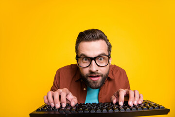 Photo portrait of bearded student playing video game crazy geek with keyboard in glasses isolated on vibrant yellow color background - obrazy, fototapety, plakaty
