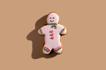 Pretty festive bakery. Valentines day pastry gift. Lovely cookies. Homemade colorful icing smiling gingerbread man isolated on beige pastel.