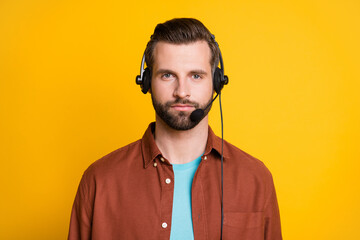 Photo portrait of serious call center worker listening in headphones with microphone isolated on...