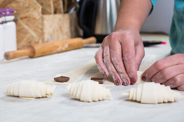 Working with puff pastry. Home baking. Raw croissant.