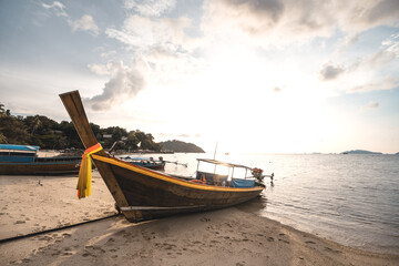 Naklejka na ściany i meble Coconut trees and long tail boats on the island in the evening