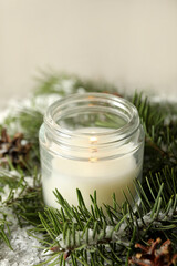 Obraz na płótnie Canvas Scented candle, pine branches and snow, close up