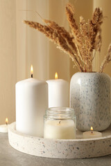 Fototapeta na wymiar Tray with scented candles and reed on gray table