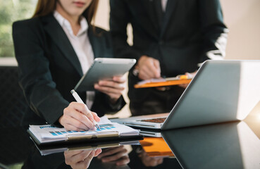 Businessmen team or financial data analysts working with tablets and laptop computers and data graphs together. Plan to analyzing projects in the office.