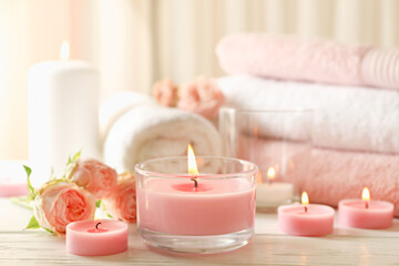 Pink scented candles on white wooden background