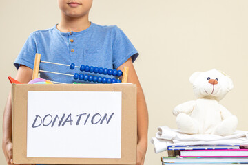 Volunteer with toys, clothes, books, donation goods in donate charity box
