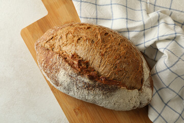 Board with bread and napkin on white table