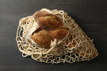 String bag with bread on black background