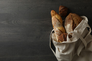 Cotton bag with bakery products on black background