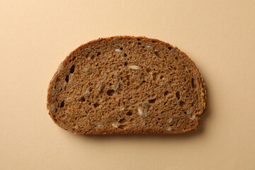 Rye bread slice on beige background, close up