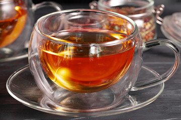 Glass tea cup and teapot on table