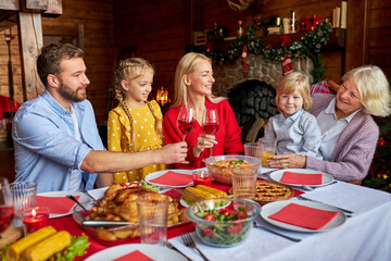 happy family clinking glasses with wine, celebrating christmas or new year, congratulating, say toast