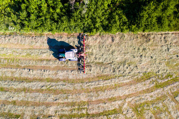 Top view of tractor with tedders, drying mowed hay