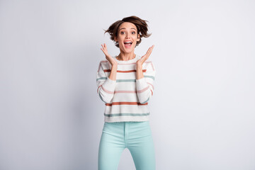 Photo of funny impressed young woman dressed striped pullover rising arms isolated grey color background