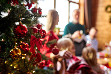 close-up photo of decorated new year tree and people celebrating holiday in the background