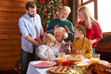 family celebrating christmas eve with traditional food and decoration, preparing turkey for dinner, have fun. new year and xmas concept
