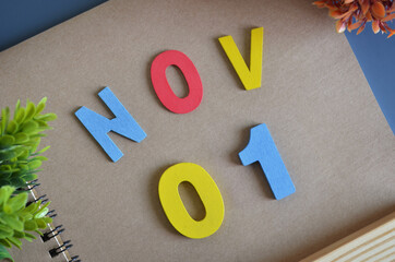 November 1, Cover design in natural concept with a brown notebook and colorful wooden alphabet.