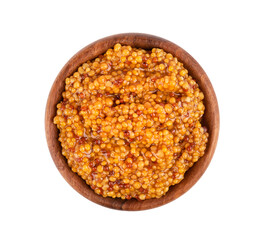 Grain mustard sauce in wooden bowl, isolated on white background. Mustard beans. Top view.