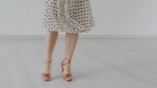 Young beautiful girl dancing ballroom dancing. A professional ballroom dancer is engaged in a large white hall.