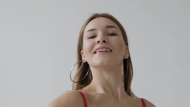 Young beautiful girl dancing ballroom dancing. A professional ballroom dancer is engaged in a large white hall.