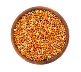 Millet in wooden bowl, isolated on white background. Unpeeled millet seeds. Top view.