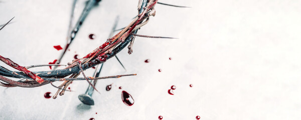 Christian crown of thorns with drops of blood, nails on grey background. Good Friday, Passion of...