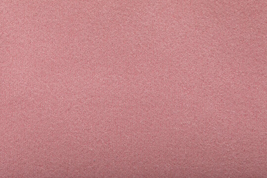 Fine grain pink texture background. Velvet scarlet matte background of suede fabric