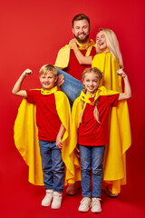 powerful strong family pretend to be superheroes, stand posing in cloaks and masks. isolated over...