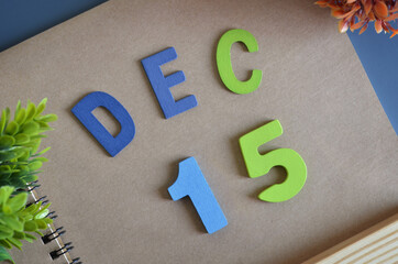 December 15, Cover design in natural concept with a brown notebook and colorful wooden alphabet.