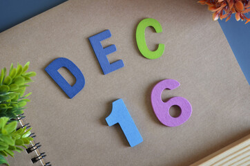 December 16, Cover design in natural concept with a brown notebook and colorful wooden alphabet.