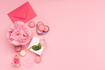 Flowers roses, gift box and sweets macaroons on pink background. Valentines day concept. Flat lay,...