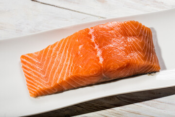 raw salmon fillet over wooden white table