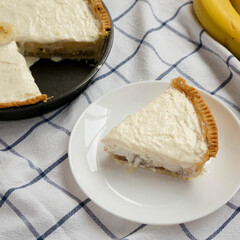 Homemade Tasty Banana Cream Pie on cloth, side view.