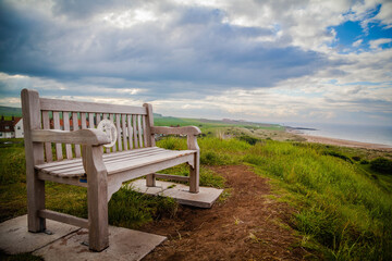 Naklejka na ściany i meble Bench overlooking the beach of Northumberland, United Kingdom