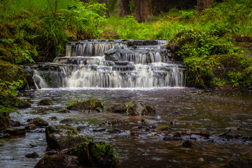Fototapeta na wymiar Small waterfall near Cragside in Northumberland, United Kingdom