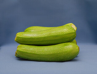 Ripe zucchini on a blue background. Levitation. Isolated. To close.
