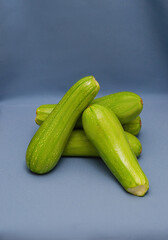 Ripe zucchini on a blue background. Levitation. Isolated. To close.