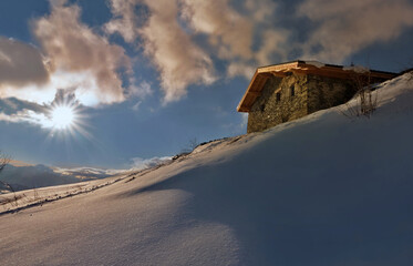 traditional french alpine chalet at the top of snowy mountain at sunset