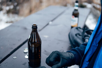 Draußen im Winter ein Bier aus der Flasche trinken