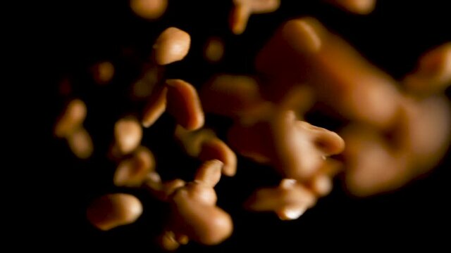 Salted Peanuts, a Healthy Organic Vegan Food, Falling in Black Background