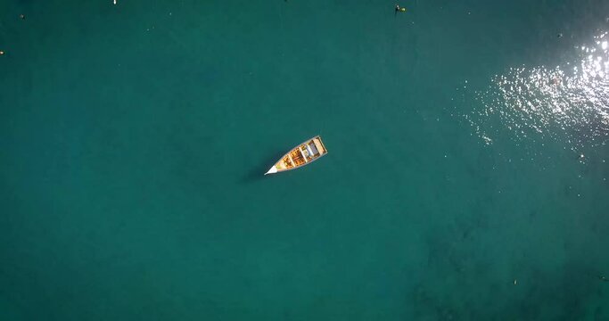 Bird eye view of a small fishing boat floating in a calm Caribbean Sea Marina