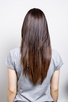 Back view of the young female with beautiful brown straight long hairs wearing casual clothes