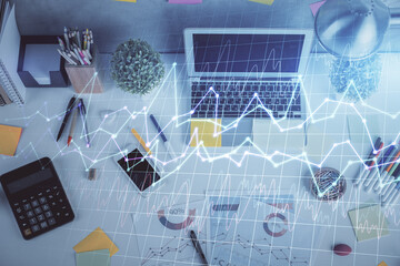 Double exposure of forex chart drawing over table background with computer. Concept of financial...