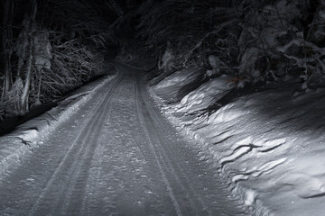 Car tracks on winter road covered with snow