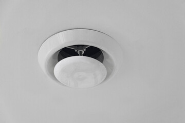 Extractor air vent fan. Modern office white simple ventilation duct on ceiling.