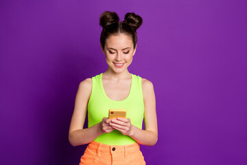 Portrait of attractive focused cheerful girl using device app 5g wi-fi isolated over bright violet purple color background