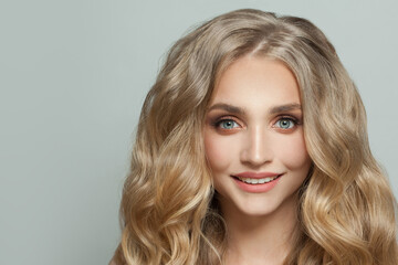 Happy smiling woman with healthy blonde curly hair portrait